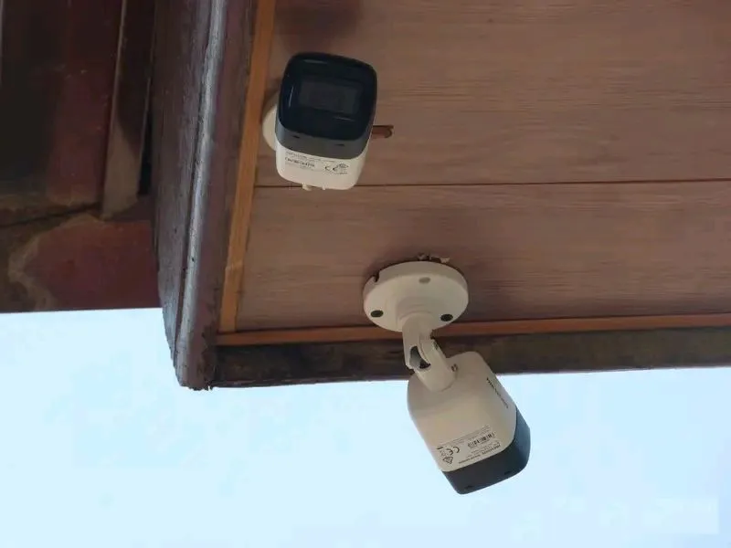 Two CCTV cameras mounted under a roof eave
