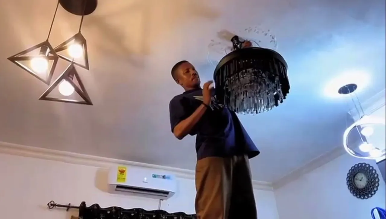 Technician installing a chandelier light fixture