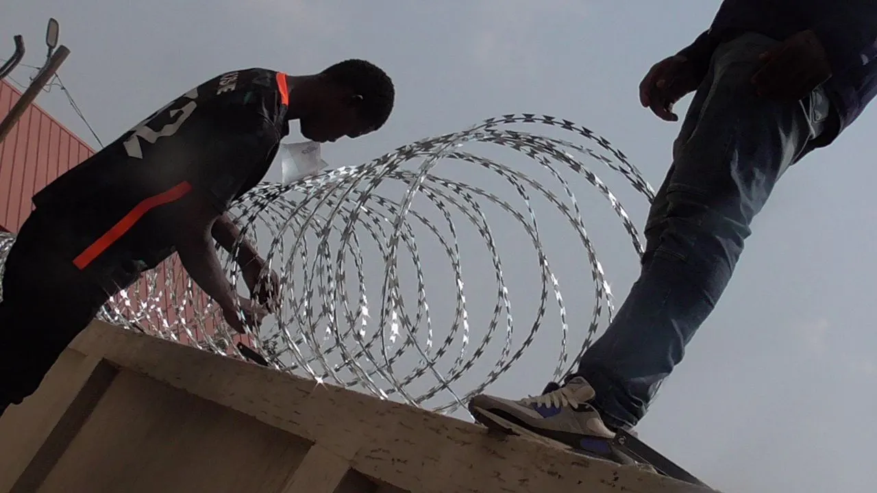 Razor wire being installed along a perimeter wall
